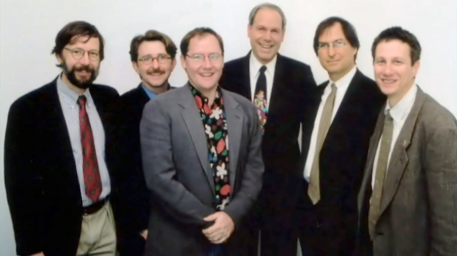 Steve Jobs poses with Disney CEO Michael Eisner (middle, dark suit) and Pixar's Ed Catmull (left-most) and John Lasseter (middle, grey suit), 1995