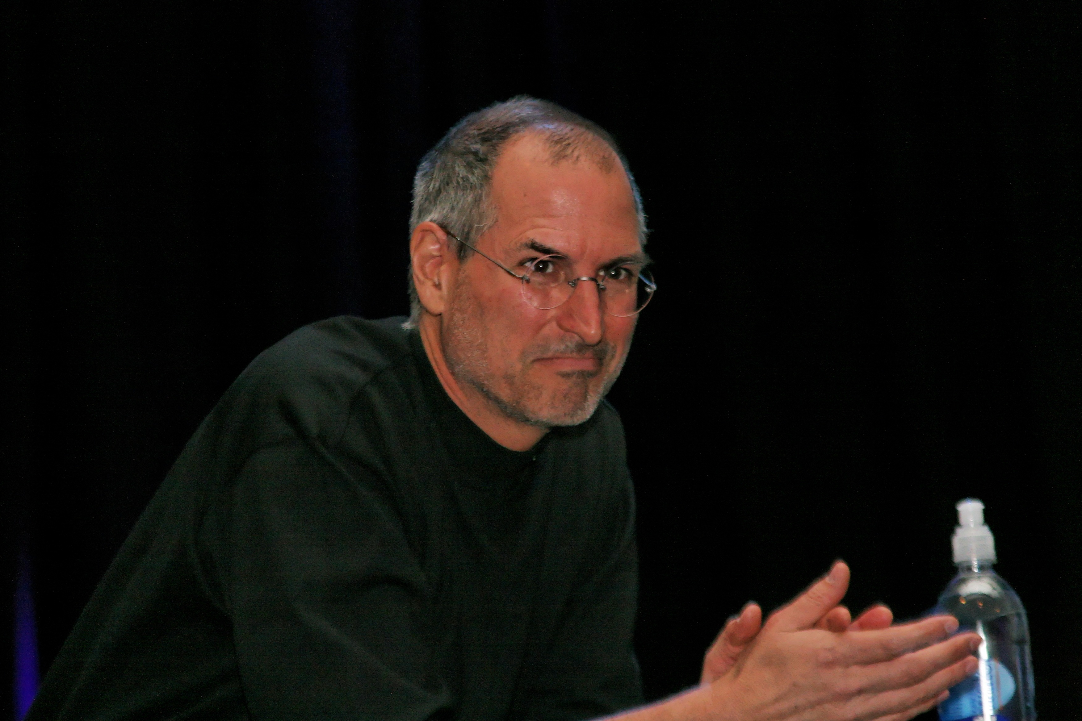 Steve Jobs watches as he hands over the stage