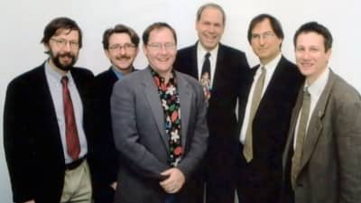 1995 - Steve Jobs poses with Disney CEO Michael Eisner (middle, dark suit) and Pixar's Ed Catmull (left-most) and John Lasseter (middle, grey suit)